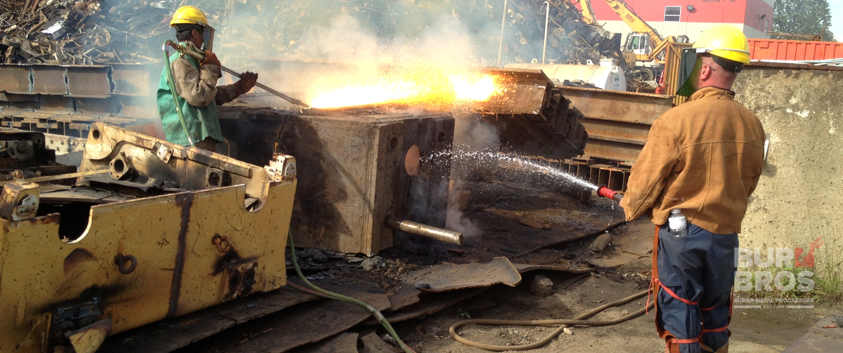 Torchman assisting other torchman while cutting steel material